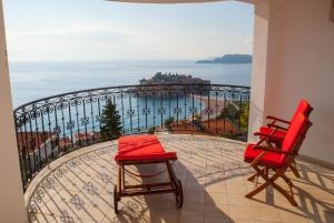 a balcony with two chairs and a view of the ocean at Villa Edelweiss in Sveti Stefan