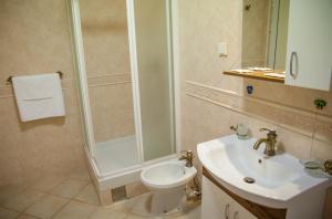 a bathroom with a shower and a toilet and a sink at Villa Edelweiss in Sveti Stefan