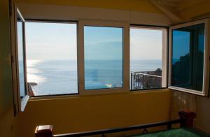 a room with three windows with a view of the ocean at Villa Edelweiss in Sveti Stefan
