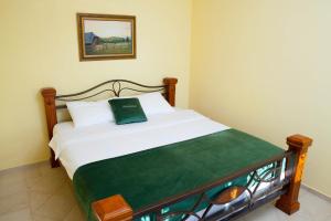 a bedroom with a bed with a green and white blanket at Villa Edelweiss in Sveti Stefan