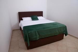 a bedroom with a bed with a green blanket on it at Villa Edelweiss in Sveti Stefan