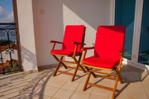 two red chairs sitting on a balcony at Villa Edelweiss in Sveti Stefan