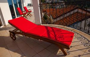 a red bench sitting on top of a balcony at Villa Edelweiss in Sveti Stefan