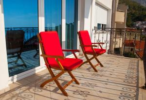 two red chairs sitting on a balcony at Villa Edelweiss in Sveti Stefan