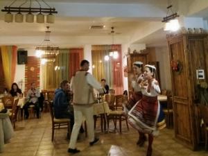 a group of people dancing in a restaurant at Pirina Club Hotel in Bansko