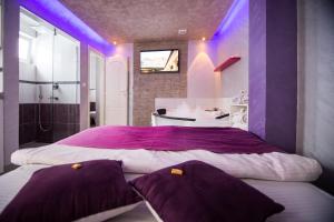 Dormitorio púrpura con cama grande y bañera en Apartments Blue House, en Zlatibor
