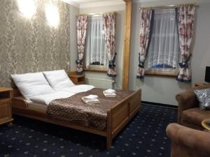 een slaapkamer met een bed en 2 ramen bij Oro Cavallo in Karpacz