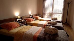 1 dormitorio con 3 camas y toallas. en Guest House Fun and Rest, en Plovdiv