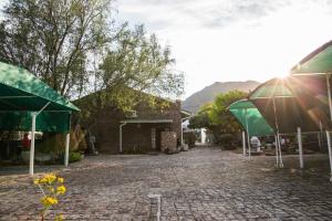 a cobblestone street with umbrellas and a building at Country Village in Graaff-Reinet