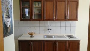 a kitchen with wooden cabinets and a sink at Villa Agava in Vrboska