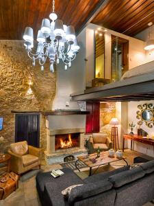 a living room with a fireplace and a couch at Oinoessa Traditional Boutique Guest Houses in Lofou