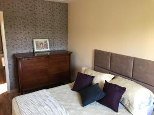 a bedroom with a bed with two pillows and a dresser at Charmoso Apartamento no Bairro Jardim in Santo André
