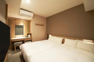 Postel nebo postele na pokoji v ubytování Sotetsu Fresa Inn Tokyo Kanda