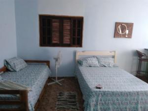 1 dormitorio con 2 camas y ventana en Ilha Céu Sol, en Ilhabela