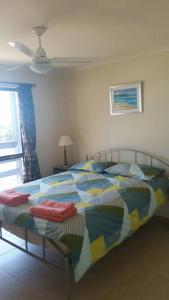 a bedroom with a bed with a colorful comforter at Pebbles Beach Retreat in Cowes