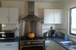 a kitchen with a stove with a pot on it at Pebbles Beach Retreat in Cowes