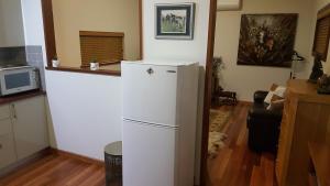 a kitchen with a white refrigerator in a room at Equestrian Farm Stay in One Tree Hill +29 photos