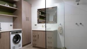 a bathroom with a sink and a washing machine at Equestrian Farm Stay in One Tree Hill
