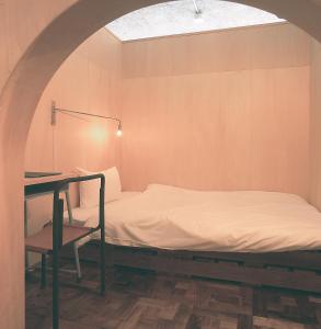 Een bed of bedden in een kamer bij Iwashi Building Hostel