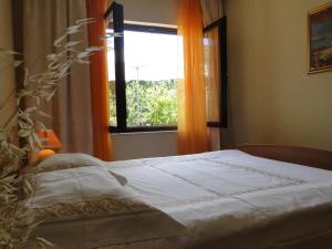 a bedroom with a bed and a window with orange curtains at Villa Agava in Vrboska