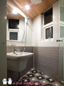 a bathroom with a sink and a mirror at Ariene Guesthouse in Gwangju