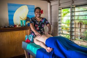 a woman sitting on top of a massage table at Likuri Island Resort Fiji in Natadola