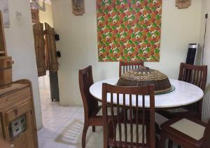 une salle à manger avec une table, des chaises et un tableau dans l'établissement Homestay Pagar Buruk Ipoh, à Ipoh