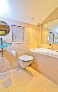 a bathroom with a toilet and a tub and a sink at Thames View House Surrey Quays in London