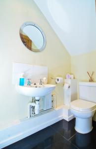 ein Badezimmer mit einem Waschbecken, einem WC und einem Spiegel in der Unterkunft Thames View House Surrey Quays in London