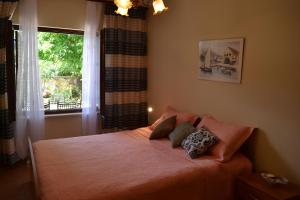 a bedroom with a bed with two pillows and a window at Villa Agava in Vrboska