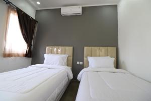 two beds sitting next to each other in a room at Diyar Villas Puncak K3/2 in Puncak