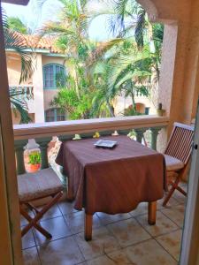 a balcony with a table and chairs and a palm tree at Wacamaya in Palm-Eagle Beach