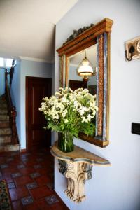 Casa Lourido Lires في Lires: إناء من الزهور على طاولة أمام مرآة
