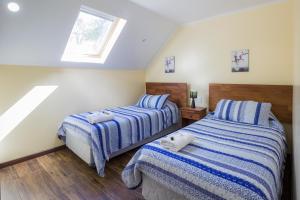 2 camas en un dormitorio con ventana en Apartamentos Entre Fronteras en Punta Arenas