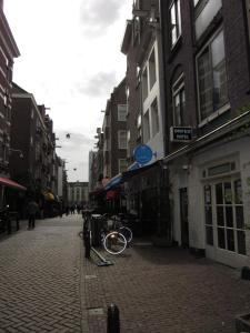 Una bicicleta estacionada en una calle en una ciudad en Amsterdam Hostel Uptown, en Ámsterdam