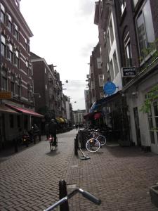 una persona montando una bicicleta por una calle de ladrillos en Amsterdam Hostel Uptown, en Ámsterdam