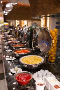 a buffet line with plates of food on a counter at Dusit Thani Guam Resort in Tumon