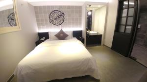 1 Schlafzimmer mit einem weißen Bett und einem Badezimmer in der Unterkunft Vovo Hotel in Seosan