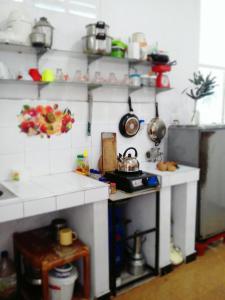 a model kitchen with white counter tops and shelves at City Bay House in Weligama