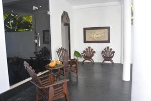 a room with chairs and a table with fruit on it at Star Nodes Villa in Galle