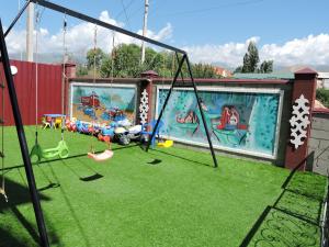 a playground with swings and a painting of a pool at Inn Kochevnik in Cholpon-Ata