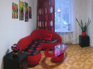 a living room with a red couch and a table at Apartment Bombonyerka in Drogobych