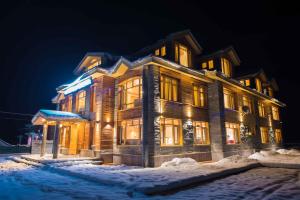 a large house in the snow at night at Hotel Imperial Resorts in Sonāmarg