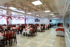 a dining room with tables and chairs with red tablecloths at Sanatorium Sosnovy Bor in Kholuy