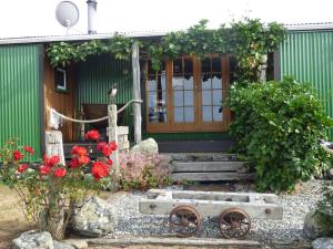 a house with a door and flowers in front of it at Hapuku Carriages Kaikōura in Kaikoura