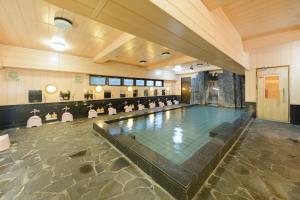 a swimming pool in a large room with a pool at Kochi Prince Hotel in Kochi