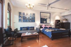 een woonkamer met een bed en een bank bij 2ROOMS Boutique House in Phuket