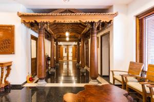 a hallway with columns and a table and chairs at Sterling Guruvayur in Guruvāyūr