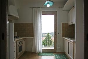 a kitchen with a large window and a door at Casa Fioredda in Aglientu