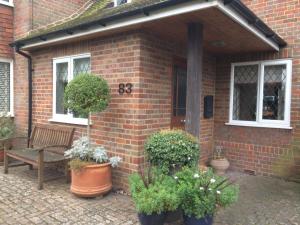 a brick house with a bench and potted plants at 83 in Aylesbury